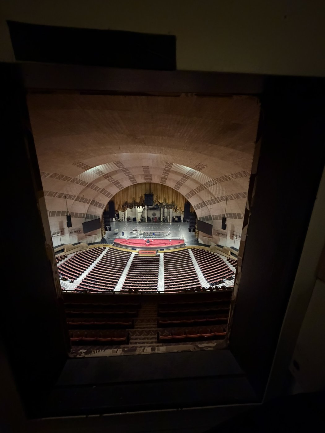 An auditorium and arched proscenium with white calibration lines across the stage.